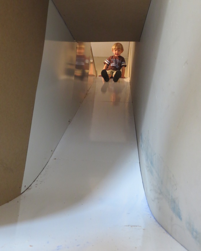 Logan about to test the slide tunnel. I created the curvature at the bottom of the slide by laminating two sheets of ¼” plywood together.