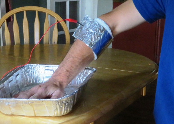 Wrapping foil around the wristband will greatly increase conductivity, reducing the amount of current required and decreasing current density where the wire is attached. This piece of foil is approximately 12" x 18". Fold it twice length-wise to create a strip 3"x18", and wrap that around the dampened wristband. Roll the two ends together and clip the wire to the roll.
